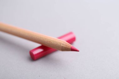 Açık gri arka planda güzel bir dudak kalemi, yakın plan. Metin için boşluk