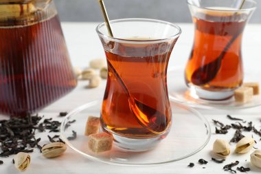 Lezzetli Türk çayı, şeker ve şam fıstığı beyaz ahşap masada, yakın plan.