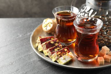Lezzetli Türk çayı ve lokum siyah masada, yakın plan. Metin için boşluk