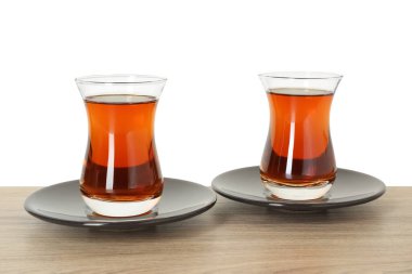 Beyaz arka plana karşı ahşap masada fincanlarda Türk çayı