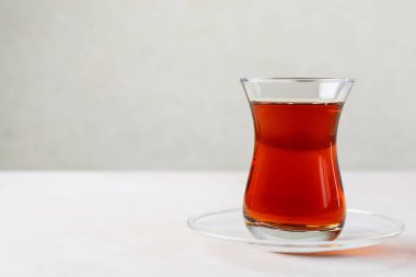 Geleneksel Türk çayı cam bardakta, beyaz masada, yakın plan. Metin için boşluk