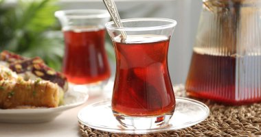 Geleneksel Türk çayı cam bardaklarda, çaydanlık ve tatlılar kapalı masada, yakın plan