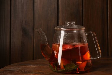 Çilekli Aromatik meyve çayı ve ahşap masada cam çaydanlık, metin için yer