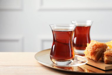 Tahta masada baklava ile servis edilen lezzetli Türk çayı. Metin için boşluk