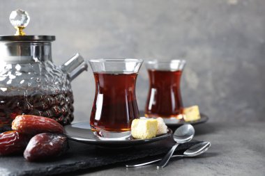 Gri masadaki şekerlerle servis edilen lezzetli Türk çayı.