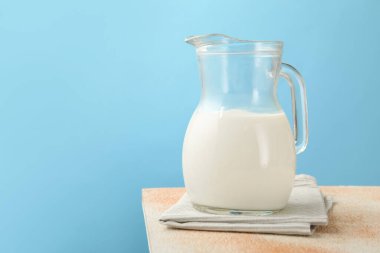 Masadaki taze süt açık mavi arka planda, yakın plan.
