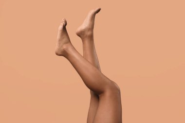 Epilasyon. Bej arka planda yumuşak tenli bacaklarını gösteren kadın, yakın plan.