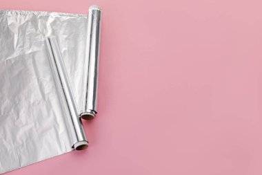 Pembe arka planda alüminyum folyo ruloları. Metin için boşluk