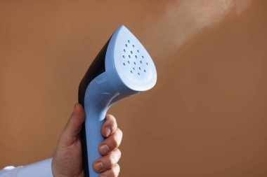 Kahverengi arka planda vapuru olan adam, yakın plan.