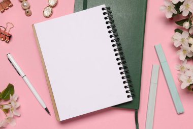 Pembe zemin üzerinde planlayıcı ve kırtasiye malzemesi, düz uzanma
