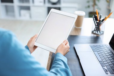 Tabletli kadın içeride, yakın plan.