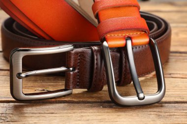 Ahşap masada iki deri kemer, yakın plan.