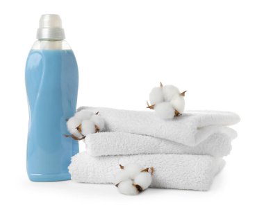 Bir şişe yumuşatıcı, pamuk çiçekleri ve beyaz üzerine izole edilmiş temiz havlular.