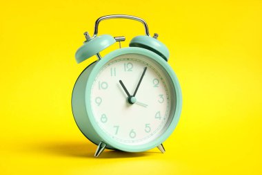 Sarı arka planda bir turkuaz alarm saati