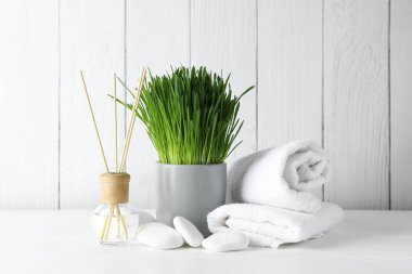 Beyaz masa üzerinde buğday çimi olan spa kompozisyonu