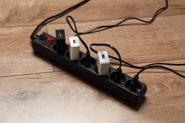 Uzatma güç panosu ahşap zemindeki prizlerle aşırı yüklendi