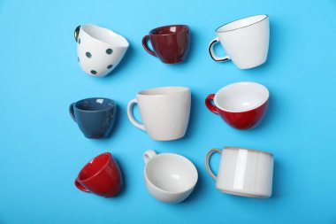 Açık mavi arkaplanda bir sürü renkli fincan, düz yatıyordu.