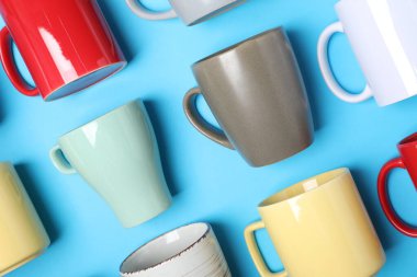 Açık mavi arkaplanda bir sürü renkli fincan, düz yatıyordu.