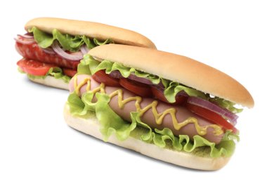 Beyaz arka planda domatesli, soğanlı, marullu ve hardallı lezzetli sosisliler.