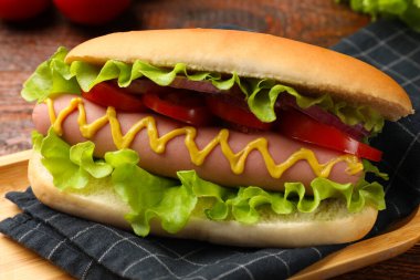 Lezzetli sosisli, domates, soğan, marul ve hardal, yakın plan.