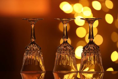 Bulanık ışıklara karşı cam ayna yüzeyinde birçok temiz bardak var. Bokeh etkisi