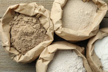 Tahta masadaki kağıt torbalarda farklı türde un var.