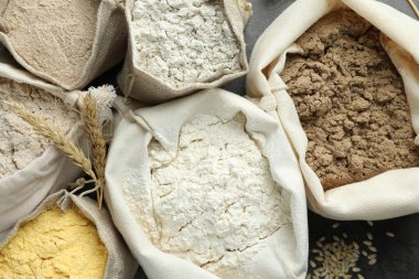 Gri masadaki poşetlerdeki farklı un türleri, düz yatıyordu.