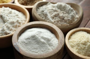 Tahta masadaki kaselerdeki farklı un türleri, yakın plan.