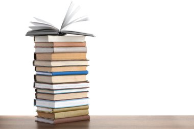 Beyaz arkaplana karşı ahşap masadaki eski kitaplar yığını