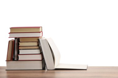 Beyaz arka plana karşı ahşap masada birçok eski kitap