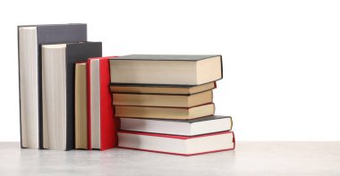 Açık gri masadaki eski kitaplar beyaz arkaplana karşı