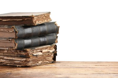 Tahta masadaki eski kitaplar beyaz arka plana karşıdır