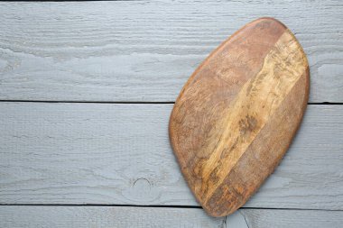 Gri ahşap masada bir tahta kesme tahtası, üst manzara. Metin için boşluk