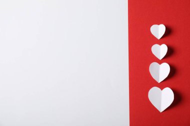 Beyaz zemin üzerinde kağıt kalpler olan kırmızı çarşaf, düz yatıyordu. Metin için boşluk
