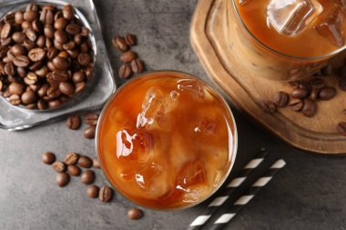 Lezzetli buzlu kahve ve fasulye gri masada, düz yerde.