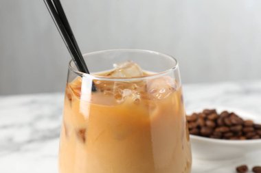 Lezzetli buzlu kahve ve fasulyeler beyaz masada, yakın plan.