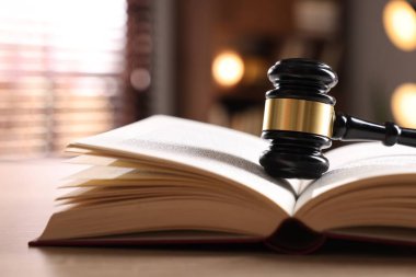 Yargıç tokmağı ve kitabı kapalı bir masa üzerinde, yakın plan.