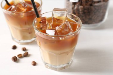 Lezzetli buzlu kahve ve fasulyeler beyaz masada, yakın plan.