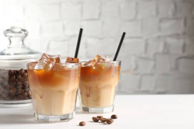 Lezzetli buzlu kahve ve fasulyeler beyaz masada. Metin için boşluk