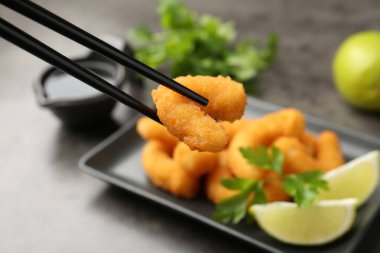 Gri masadaki çubuklu lezzetli tempura karideslerini seçici bir şekilde...