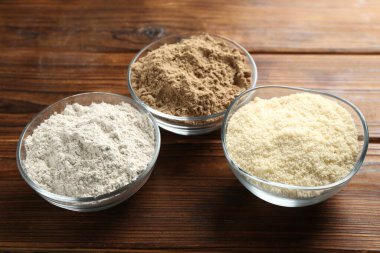 Tahta masadaki kaselerdeki farklı un türleri, yakın plan.