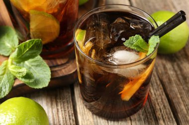 Küba libre kokteylini ahşap masada nane şekeri ile tazeliyorum.