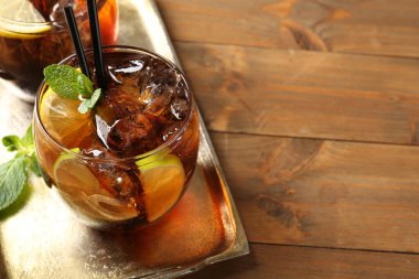 Küba libre kokteylini ahşap masada nane şekeri ile tazeliyorum, yakın plan. Metin için boşluk