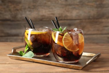 Küba libre kokteylini ahşap masada nane şekeriyle tazeliyorum.