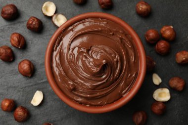 Lezzetli çikolatalı fındık ezmesi ve fındıklar siyah masada, düz yatıyordu.