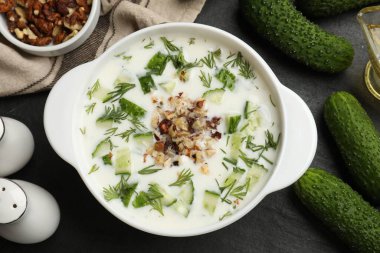 Taze leziz salatalık çorbası ve siyah masa üzerindeki malzemeler.