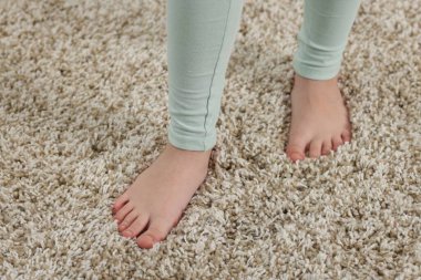 Evdeki yumuşak halıdaki kız, manzaranın üstünde.