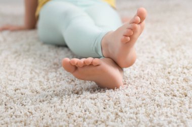 Evdeki yumuşak halıdaki kız, yakın plan.