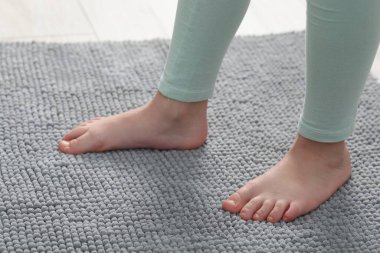 Evdeki yumuşak halıdaki kız, yakın plan.