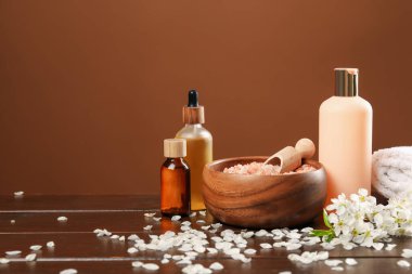Kaplıca kompozisyonu kozmetik ürünleri ve ahşap masada güzel çiçekler, yakın plan. Metin için boşluk